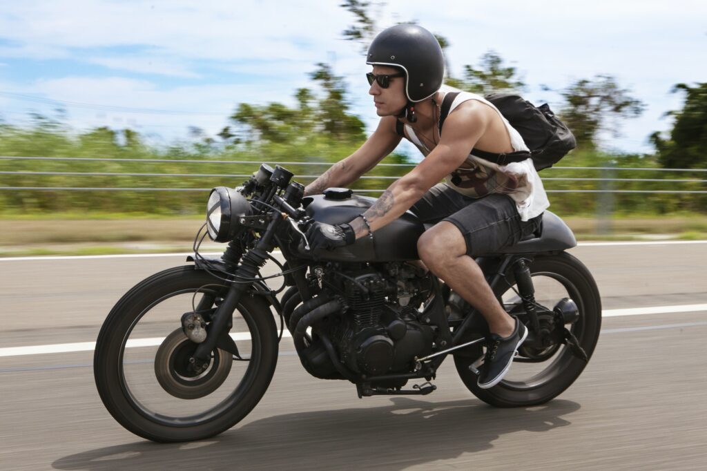 man-with-backpack-riding-motorcycle-on-road.jpg